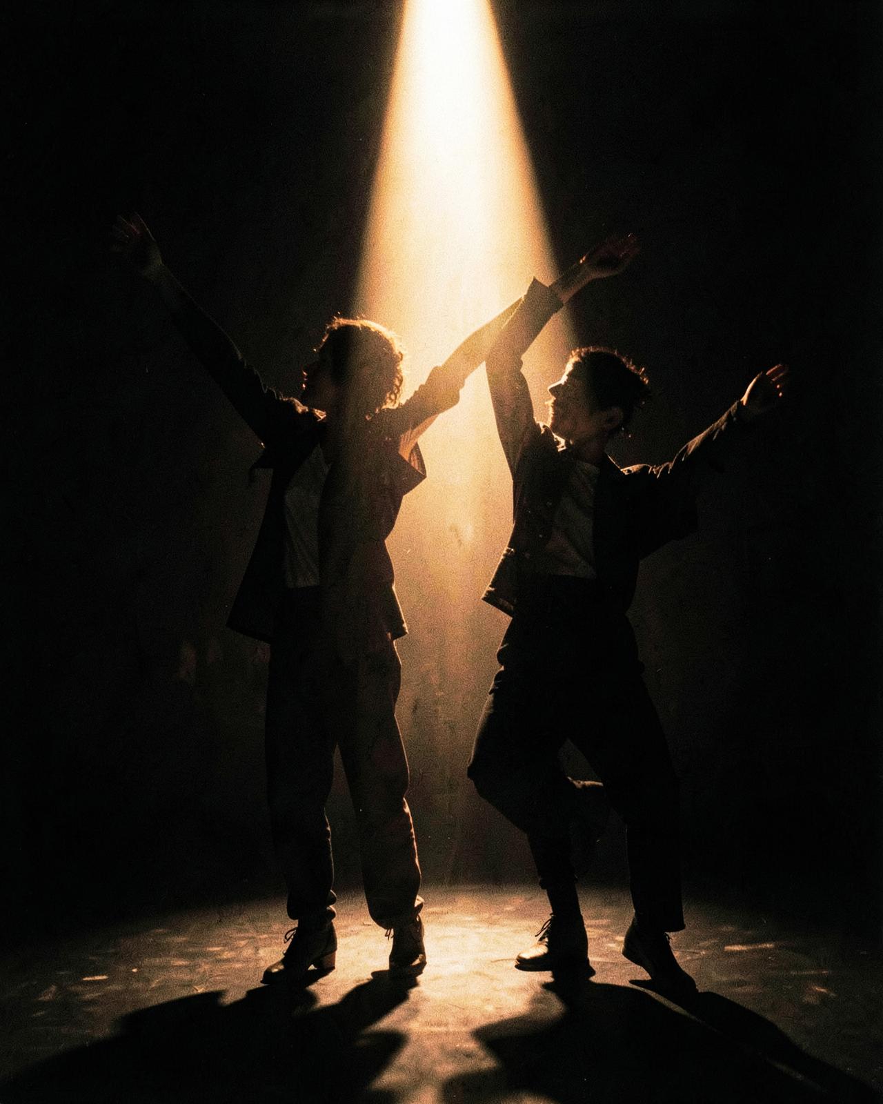 Due danzatori con stili diversi in controluce durante una lezione di Dance Fusion